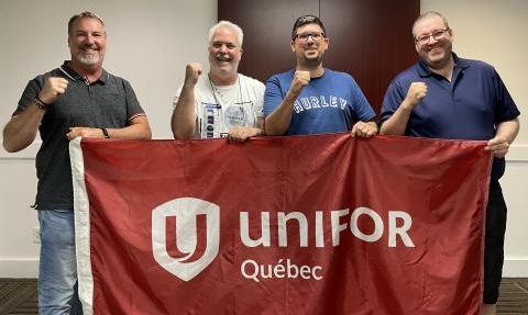 4 homme derrière un drapeau unifor Québec rouge